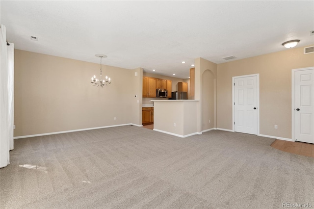 12784 Jasmine St Unit E, Thornton, CO 80602 - unfurnished living room featuring a chandelier, light colored carpet, and recessed lighting