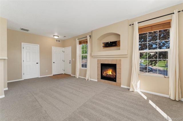 12784 Jasmine St Unit E, Thornton, CO 80602 - unfurnished living room featuring a tiled fireplace and carpet floors