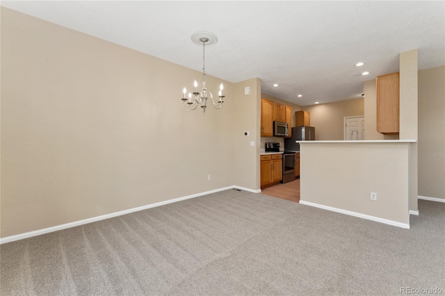 12784 Jasmine St Unit E, Thornton, CO 80602 - kitchen featuring appliances with stainless steel finishes, light carpet, a chandelier, light countertops, and recessed lighting