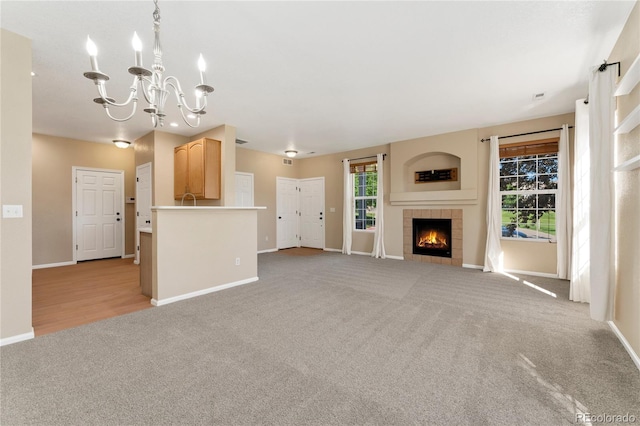 12784 Jasmine St Unit E, Thornton, CO 80602 - unfurnished living room featuring light carpet, a chandelier, and a fireplace