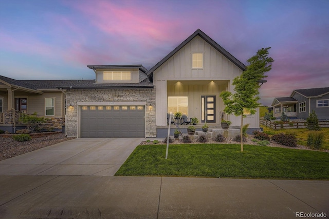 5668 Shadescale Way, Castle Rock, CO 80104 - view of front of home featuring board and batten siding, covered porch, driveway, a lawn, and a garage