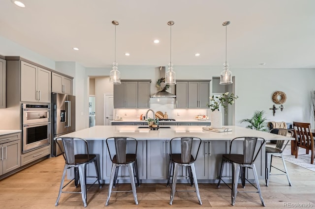 5668 Shadescale Way, Castle Rock, CO 80104 - kitchen with gray cabinetry, wall chimney range hood, high quality fridge, double oven, and recessed lighting