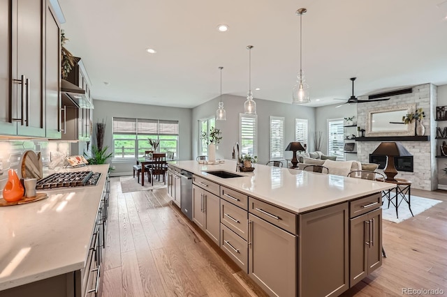 5668 Shadescale Way, Castle Rock, CO 80104 - kitchen featuring a fireplace, light countertops, light wood-style floors, a ceiling fan, and recessed lighting