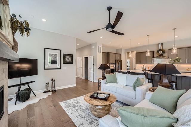 5668 Shadescale Way, Castle Rock, CO 80104 - living room featuring ceiling fan, a glass covered fireplace, wood finished floors, and recessed lighting