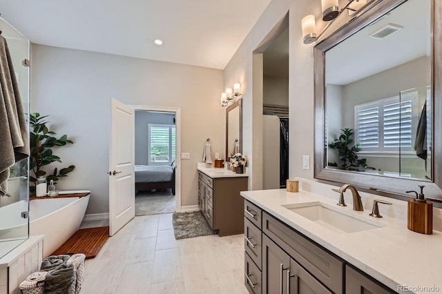 5668 Shadescale Way, Castle Rock, CO 80104 - ensuite bathroom featuring two vanities, a soaking tub, and recessed lighting
