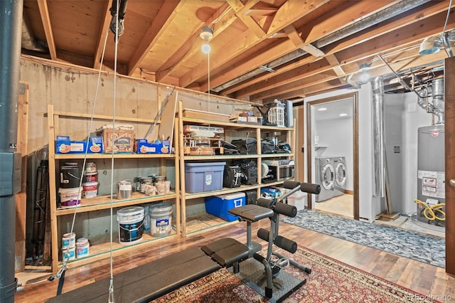 interior space with water heater, washer and clothes dryer, and wood-type flooring