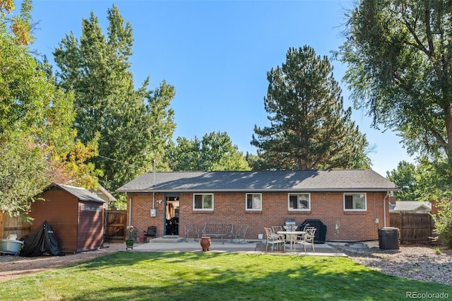 rear view of house with a lawn, central air condition unit, a patio, and a shed