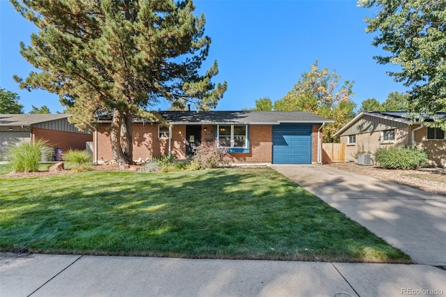 ranch-style home featuring cooling unit, a garage, and a front yard