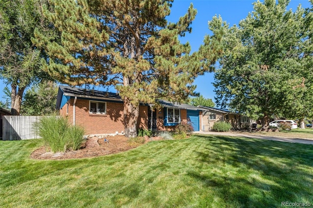 single story home featuring a garage and a front yard