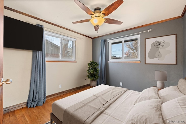 bedroom featuring light wood-type flooring, multiple windows, crown molding, and ceiling fan