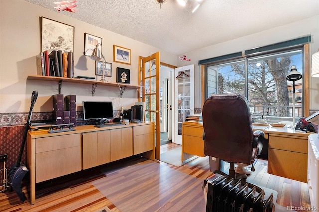 office space with light wood-type flooring and a textured ceiling
