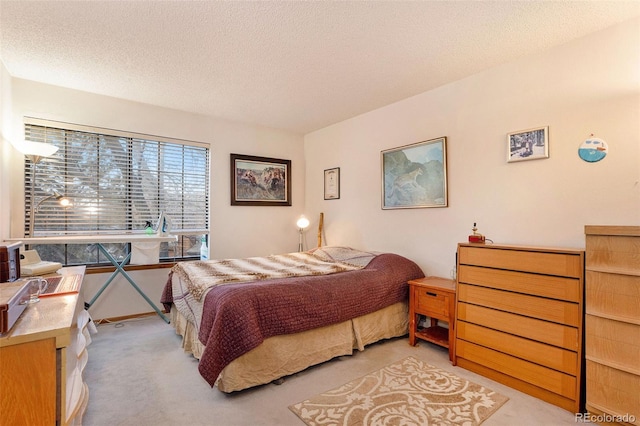 bedroom featuring light carpet and a textured ceiling