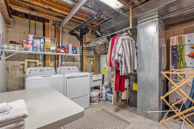unfinished basement with washing machine and dryer, water heater, and a sink