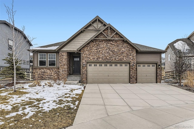 craftsman inspired home featuring an attached garage, stone siding, and driveway