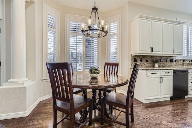 dining area featuring decorative columns, dark hardwood / wood-style flooring, and a notable chandelier