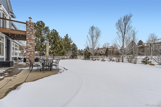 yard layered in snow featuring a patio and cooling unit