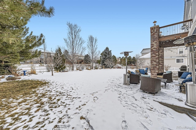 yard layered in snow with an outdoor hangout area