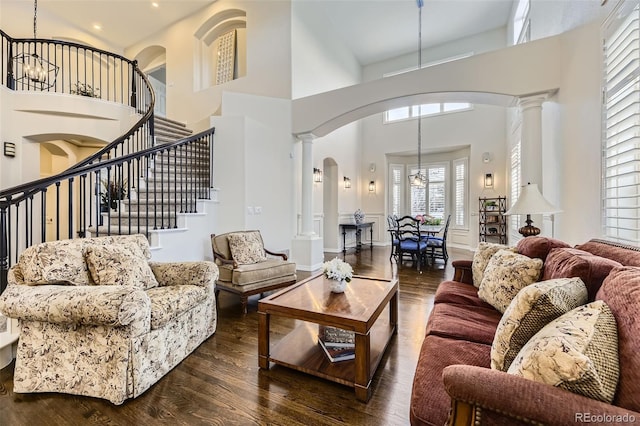 living room featuring decorative columns, dark hardwood / wood-style floors, and a high ceiling