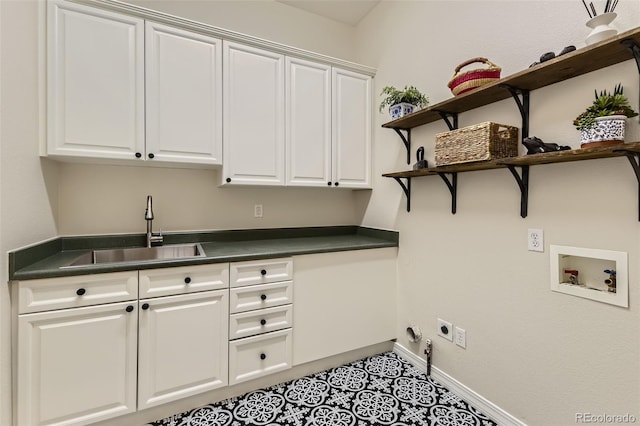 washroom featuring sink, hookup for a washing machine, hookup for an electric dryer, cabinets, and light tile patterned flooring