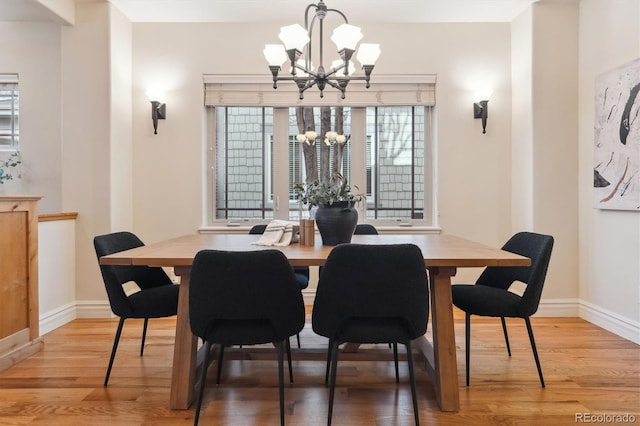 dining space featuring an inviting chandelier and light hardwood / wood-style floors