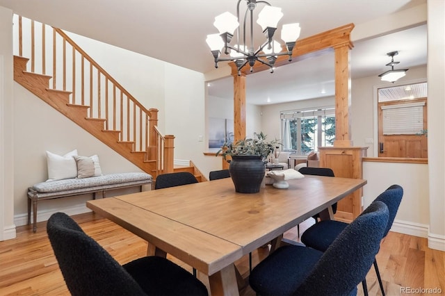 dining area with light hardwood / wood-style flooring and an inviting chandelier