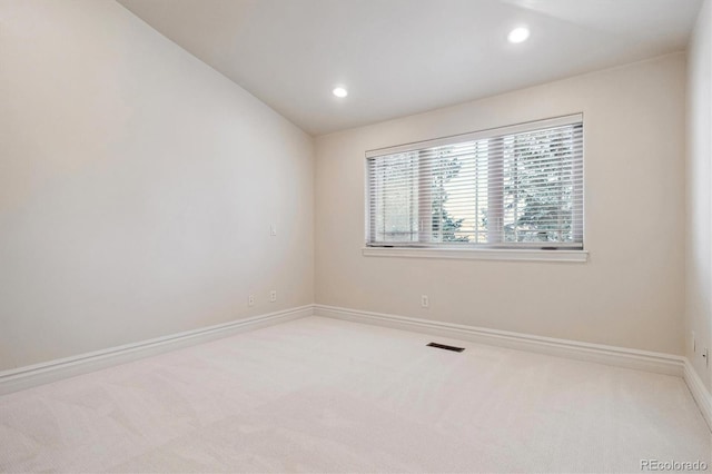 carpeted spare room with lofted ceiling