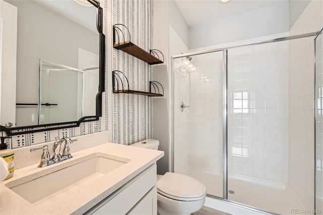 bathroom with an enclosed shower, vanity, and toilet