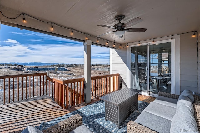 wooden deck with an outdoor living space, a mountain view, and ceiling fan