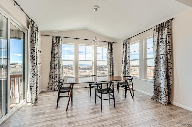 dining area featuring lofted ceiling and light hardwood / wood-style flooring