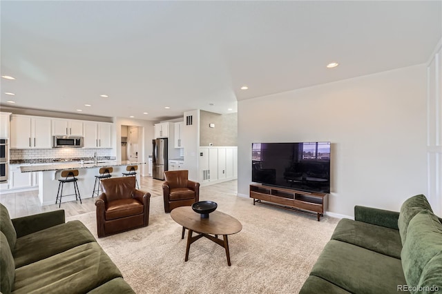 living room featuring sink and light hardwood / wood-style flooring