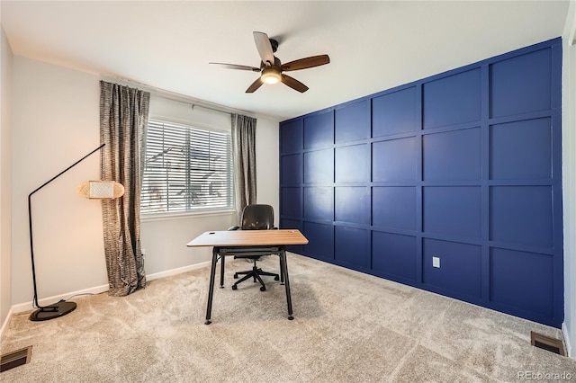 carpeted home office featuring ceiling fan