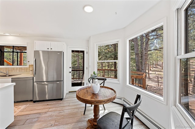 133 Mine Ln, Boulder, CO 80302 - kitchen featuring stainless steel appliances, light countertops, light wood-style floors, decorative backsplash, and white cabinetry