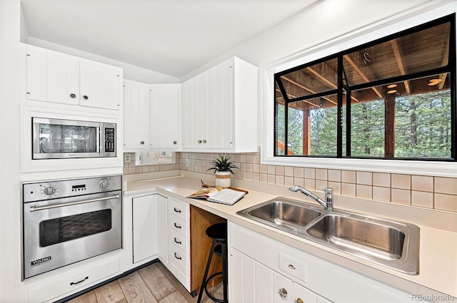 133 Mine Ln, Boulder, CO 80302 - kitchen with appliances with stainless steel finishes, light countertops, light wood finished floors, and white cabinets
