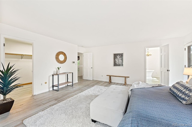 133 Mine Ln, Boulder, CO 80302 - bedroom featuring light wood-style flooring, a chandelier, a spacious closet, and connected bathroom