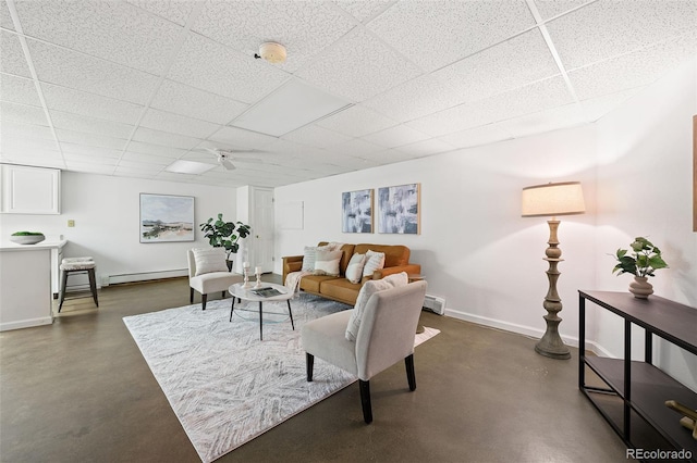 133 Mine Ln, Boulder, CO 80302 - living room featuring finished concrete flooring, ceiling fan, baseboard heating, and a paneled ceiling