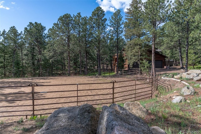 133 Mine Ln, Boulder, CO 80302 - view of yard with a garage, an enclosed riding area, driveway, and a view of trees