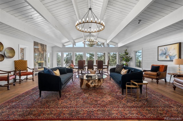 living room featuring hardwood / wood-style floors, lofted ceiling with beams, and a chandelier