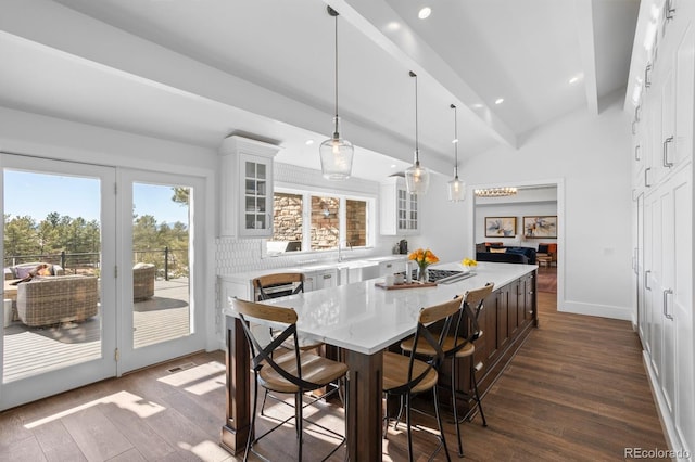 dining area featuring dark hardwood / wood-style flooring, beam ceiling, and high vaulted ceiling