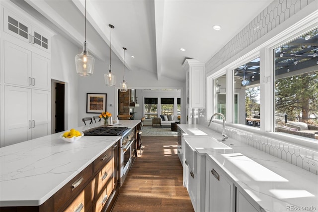 kitchen featuring white cabinetry, vaulted ceiling with beams, and decorative light fixtures