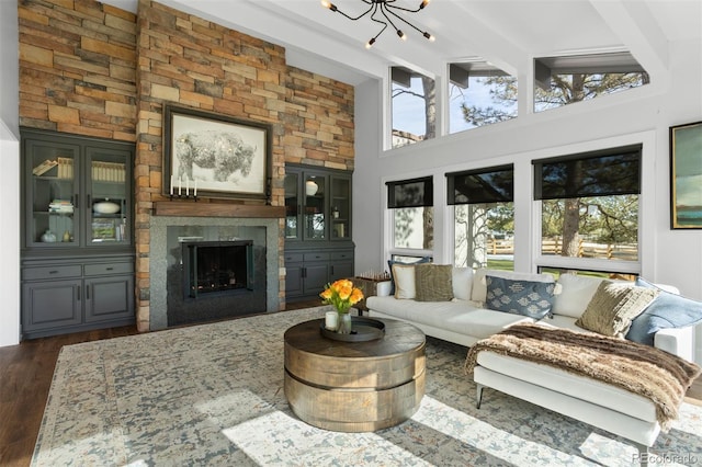 sunroom with a notable chandelier, a wealth of natural light, and lofted ceiling with beams