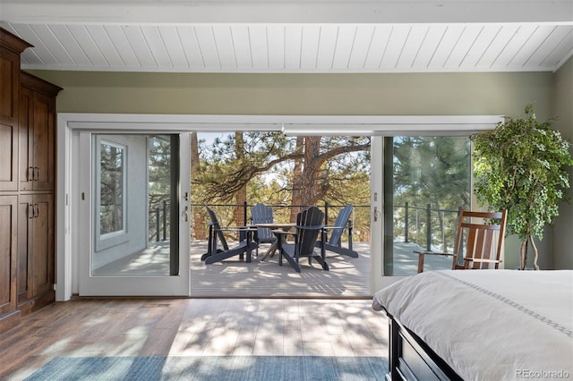 bedroom with wood ceiling, light hardwood / wood-style floors, and access to outside