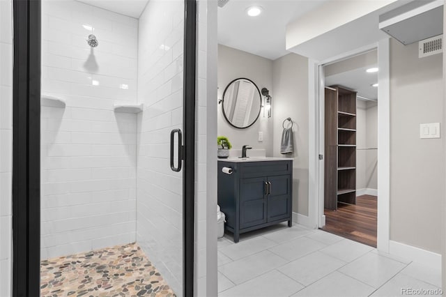 bathroom featuring vanity, a shower with shower door, and tile patterned floors