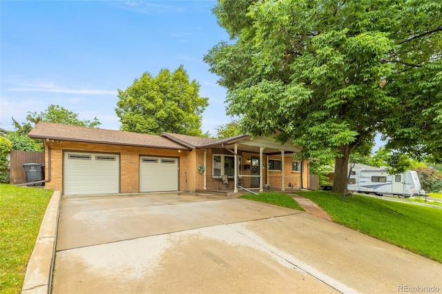 2876 S Wolff St, Denver, CO 80236 - single story home with brick siding, a porch, a garage, and concrete driveway
