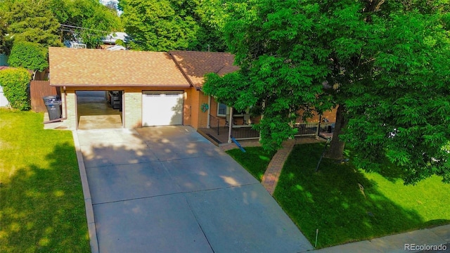 2876 S Wolff St, Denver, CO 80236 - view of front of house featuring driveway, a front lawn, and brick siding