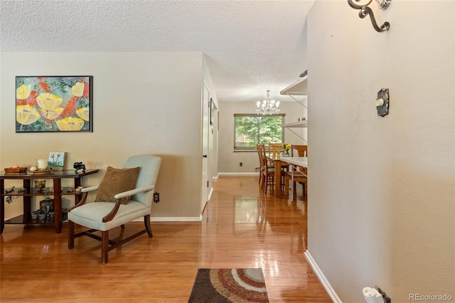 2876 S Wolff St, Denver, CO 80236 - hall featuring a chandelier, a textured ceiling, and light wood-style flooring