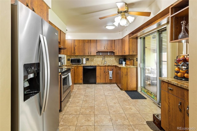 2876 S Wolff St, Denver, CO 80236 - kitchen featuring stainless steel appliances, brown cabinetry, tasteful backsplash, ceiling fan, and light stone countertops