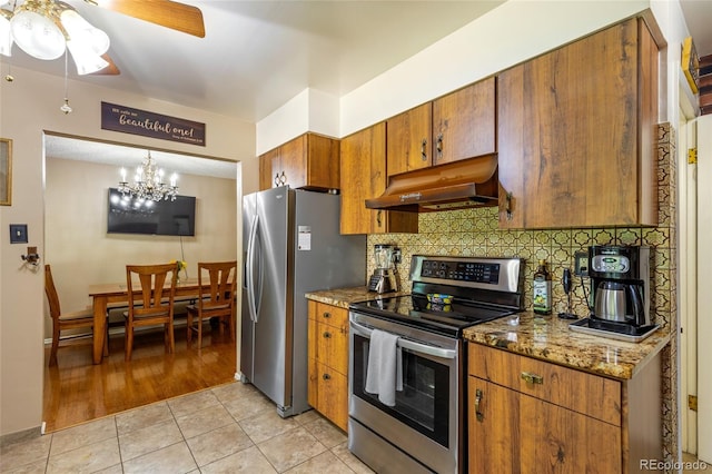 2876 S Wolff St, Denver, CO 80236 - kitchen featuring appliances with stainless steel finishes, range hood, brown cabinetry, a ceiling fan, and decorative backsplash