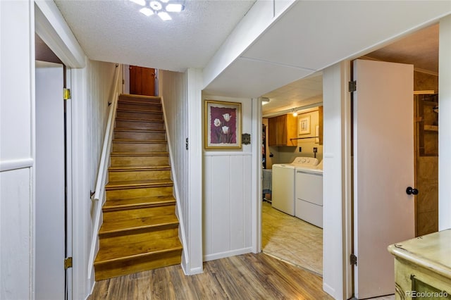 2876 S Wolff St, Denver, CO 80236 - stairway with washing machine and dryer, wood finished floors, wood walls, and a textured ceiling