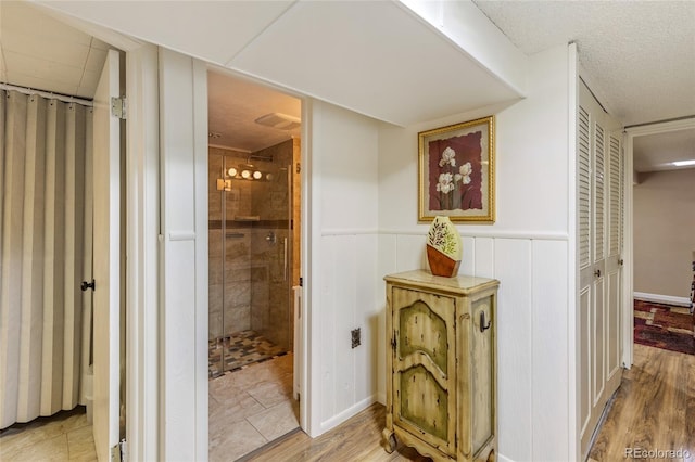 2876 S Wolff St, Denver, CO 80236 - bathroom featuring a stall shower, wainscoting, and wood finished floors