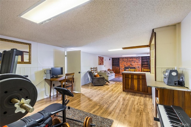 2876 S Wolff St, Denver, CO 80236 - home office featuring a brick fireplace, light wood finished floors, and a textured ceiling